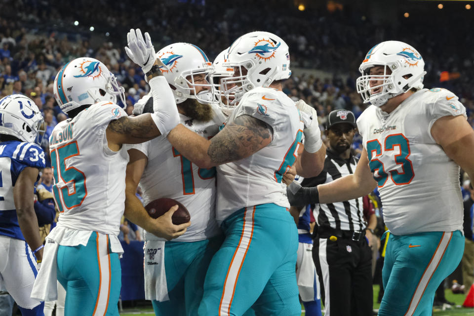 Miami Dolphins quarterback Ryan Fitzpatrick (14) is surrounded by teammates as he celebrates a touchdown against the Indianapolis Colts during the first half of an NFL football game in Indianapolis, Sunday, Nov. 10, 2019. (AP Photo/AJ Mast)