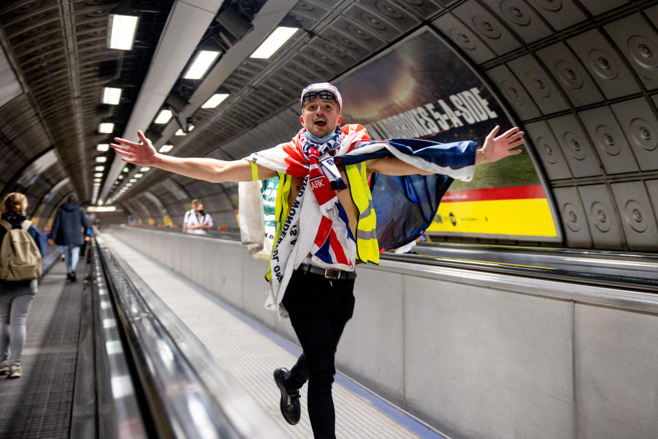 A jubilant football fan seen celebrating the triumph of England team at Waterloo Station, London.