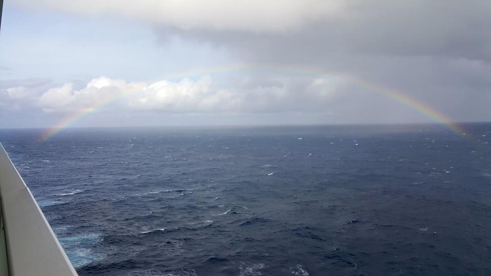 rainbow over ocean on cruise ship balcony