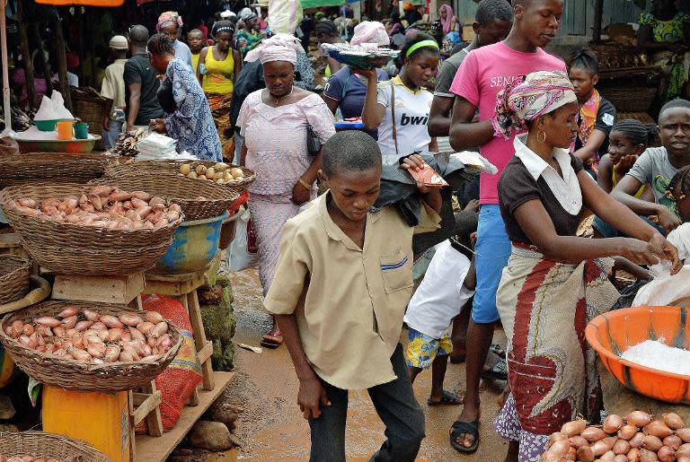 Locals walk in a market in Kenema, Sierra Leone, on August 16, 2014