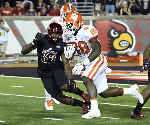 Clemson’s Tavien Feaster (28) runs from the defense of Louisville’s Stacy Thomas. (AP Photo/Timothy D. Easley)