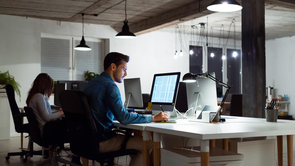 Businesswoman and businessman working late creative office.