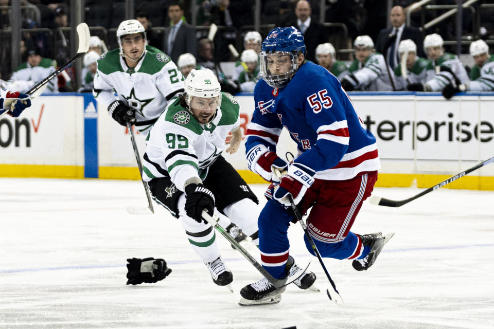 New York Rangers defenseman Ryan Lindgren (55) and Dallas Stars center Matt Duchene (95) fight for the puck during the first period of an NHL hockey game on Tuesday, Feb. 20, 2024 in New York. (AP Photo/Peter K. Afriyie)