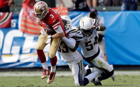 San Francisco 49ers quarterback C.J. Beathard, left, is sacked by Los Angeles Chargers defensive back Derwin James, center, and defensive end Melvin Ingram during the second half of an NFL football game - Credit: (AP Photo/Marcio Sanchez)