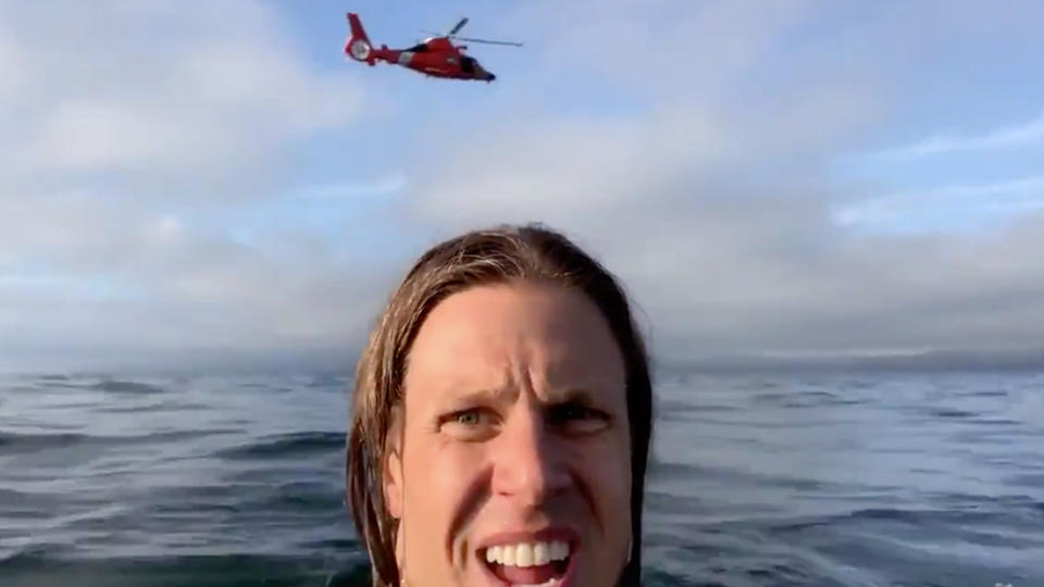 David Lesh in the water after the plane crash while rescue plane flies above. 