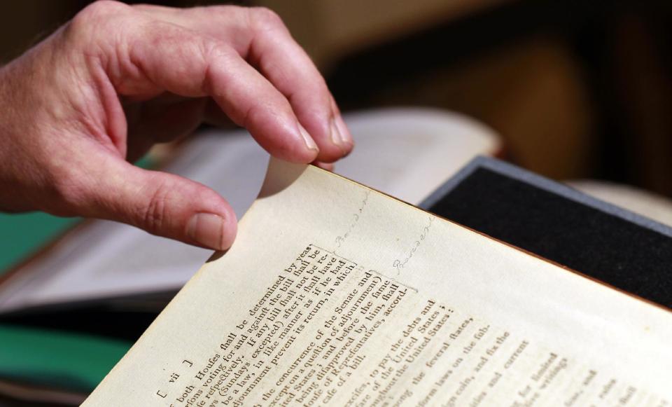 George Washington's notes in the margin are seen as Chris Coover, senior specialist for rare books & manuscripts at Christie's, shows President George Washington's personal copy of the Acts of the first Congress (1789), containing the U.S. Constitution and the proposed Bill of Rights, during a media availability, Tuesday, June 12, 2012, in Washington. The book will go on auction June 22nd and is expected to bring between $2-3 million. (AP Photo/Alex Brandon)