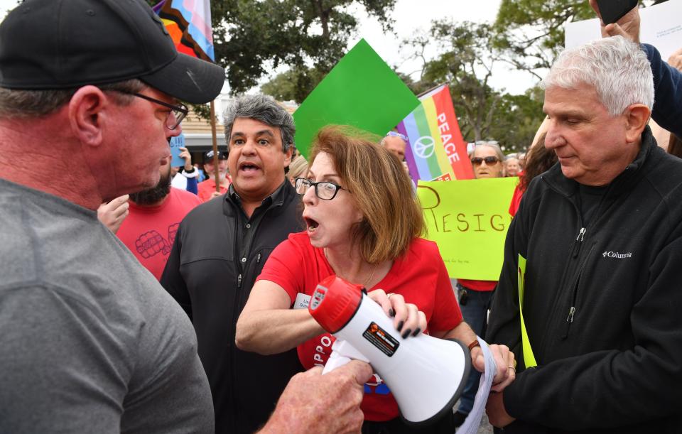 Lisa Schurr, center, with Support Our Schools, briefly stops John Wilson, right, from using his megaphone after Wilson tried to disrupt a protest outside the Sarasota County School Board Tuesday evening, De.b 12, 2023 in Sarasota, Florida. Demonstrators gathered before the board meeting to call for the resignation of school board member Bridget Ziegler after admitting to involvement in a three-way sexual relationship.