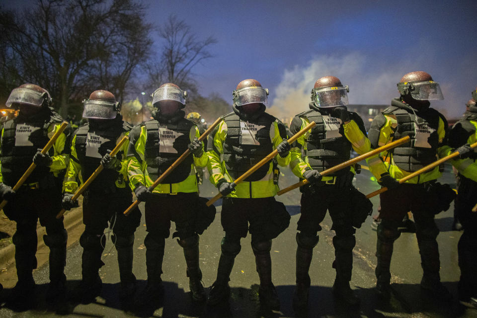 Tear gas rises from behind a line of Minnesota State Troopers as they block the road from anyone going back towards the Brooklyn Center police station where people protesting the police killing of Daunte Wright in Brooklyn Center, Minnesota, U.S., on April 13, 2021.<span class="copyright">Christopher Mark Juhn—Anadolu Agency/Getty Images</span>