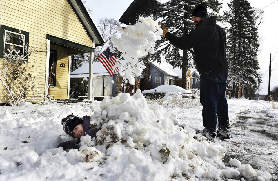 Tim Kalik shovels snow onto his daughter, Lucy, 9, in Stillwater, Minn. on Wednesday morning, Nov. 27, 2019. Lucy has a snow day from school today and is waiting for her friends to go sledding. Tim said he drove into St. Paul to his workplace but they let employees go home around 8:30 due to the weather. (Jean Pieri/Pioneer Press via AP)