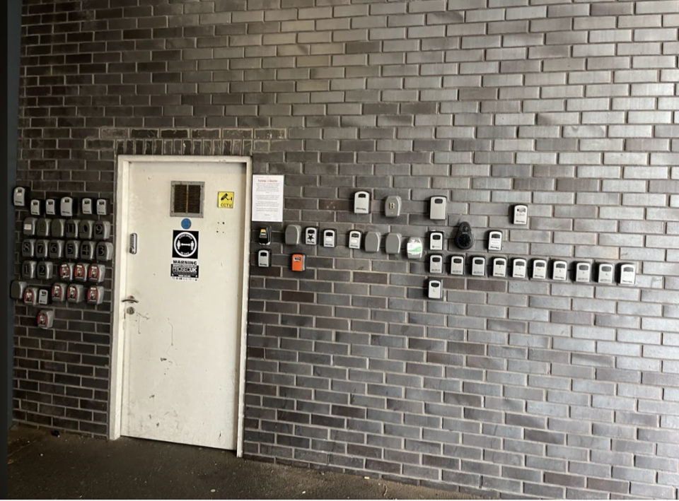 A bunch of key safes near a door