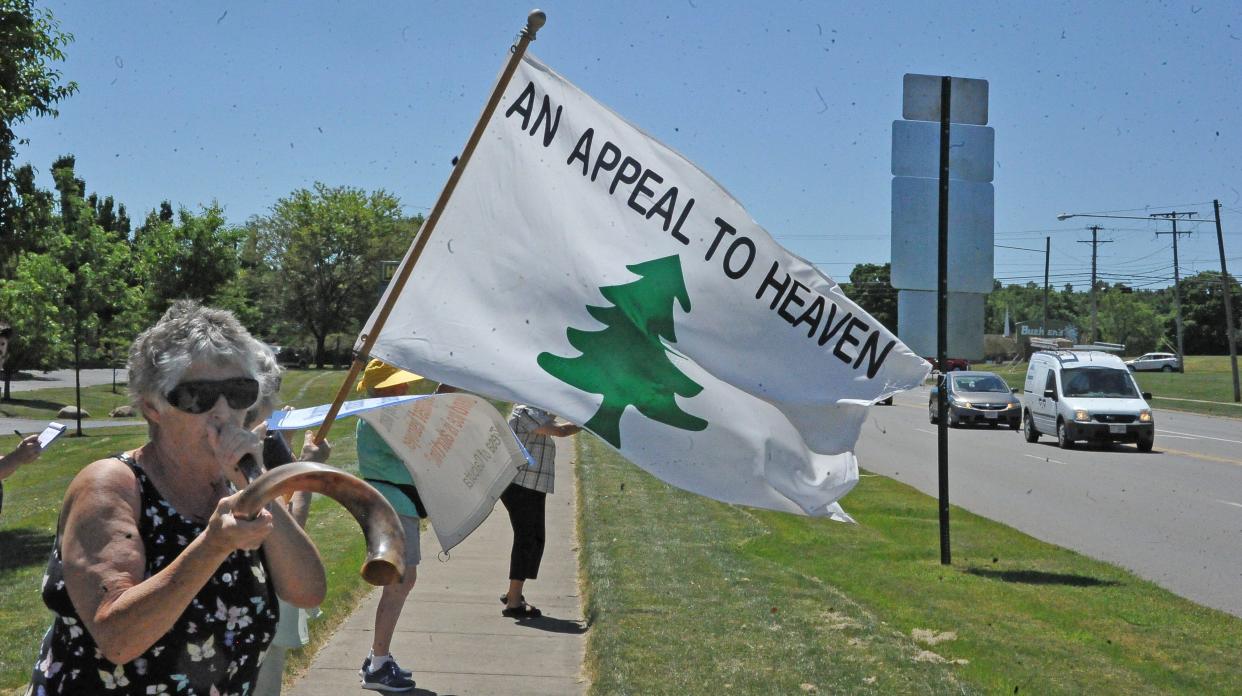 Cindy Deppe blows a horn as Susan Sonnett holds a banner during the pro-life rally.