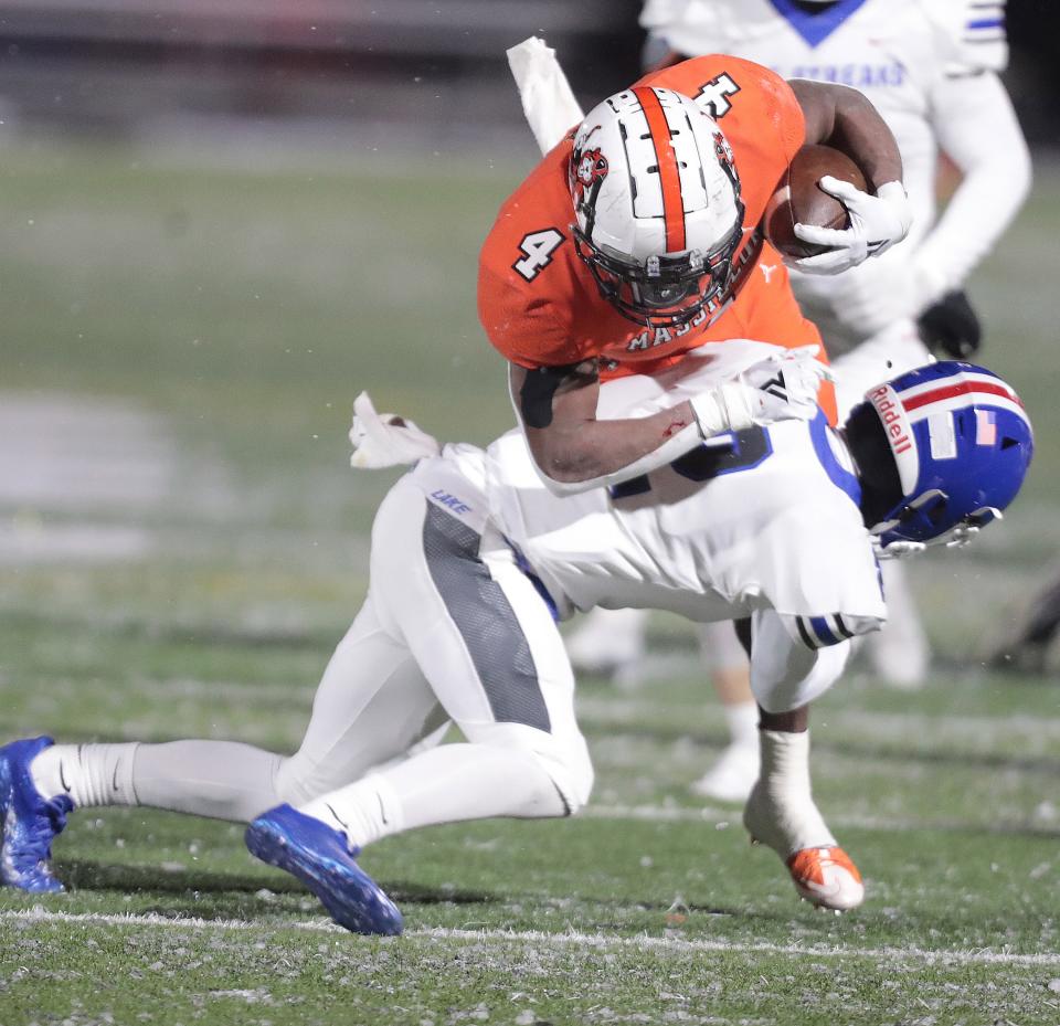 Massillon's Willtrell Hartson is upended by Lake defender Nathan Baker in the first half at Byers Field in Parma during their Div.II regional final game.