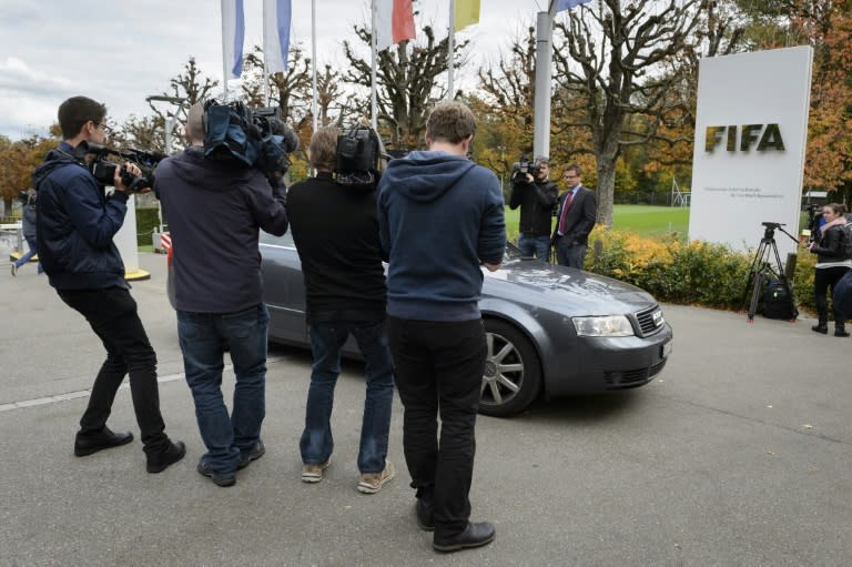 Television film crews film a car leaving the FIFA headquarters on October 8, 2015 in Zurich