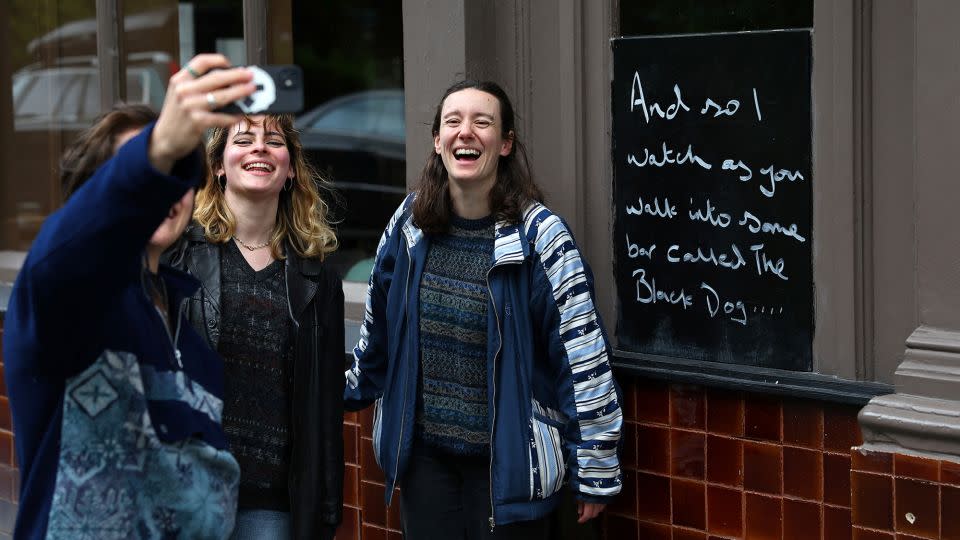 The Black Dog pub says the past few days have been "immense." Pictured here: people posing for photos outside the pub's exterior. - Toby Melville/Reuters