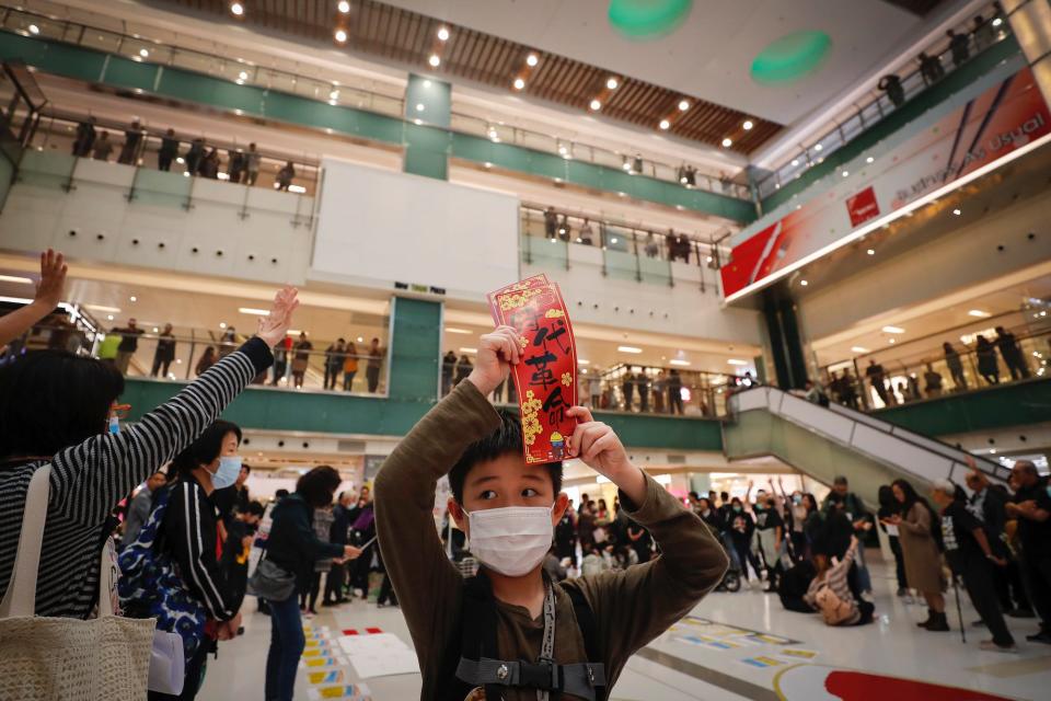 A child holds up Chinese Lunar New Year greeting papers baring the words 