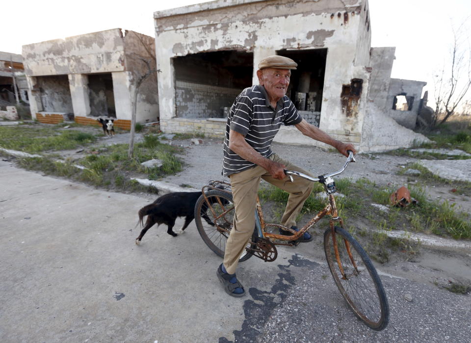 Lone inhabitant Pablo Novak, aged 85, rides his bike by a ruined house in the Epecuen Village, November 6, 2015.  Over the past few years the town of Epecuen, located 550 km (341 miles) southwest of Buenos Aires, has been attracting tourists with its eerie apocalyptic atmosphere after a flood submerged it in salt water for more than two decades. Originally a busy lakeside tourist village in the 1920s renowned for its saltwater baths, Epecuen came to a sudden end in November 10, 1985 when a succession of rainy winters caused Lago Epecuen to overflow and water surged through a special retaining wall and into the town. Residents and tourists were forced to evacuate and in just a few days homes and buildings were covered by almost 10 meters (33 feet) of salt water. Now, 30 years on, the water has evaporated and former residents can walk amidst the rusted out ruins of what was once their town. Picture taken November 6, 2015. REUTERS/Enrique Marcarian