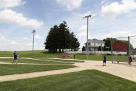 Visitors play on the field at the Field of Dreams movie site, Friday, June 5, 2020, in Dyersville, Iowa. Major League Baseball is building another field a few hundred yards down a corn-lined path from the famous movie site in eastern Iowa but unlike the original, it's unclear whether teams will show up for a game this time as the league and its players struggle to agree on plans for a coronavirus-shortened season. (AP Photo/Charlie Neibergall)