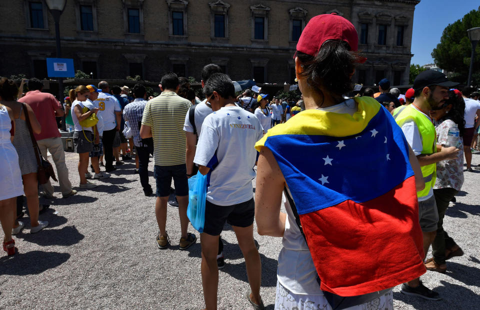 <p>Venezuelan residents in Madrid queue to vote during a symbolic plebiscite on president Maduro’s project of a future constituent assembly, called by the Venezuelan opposition and held at the Puerta del Sol in Madrid on July 16, 2017. (Gerard Julien/AFP/Getty Images) </p>