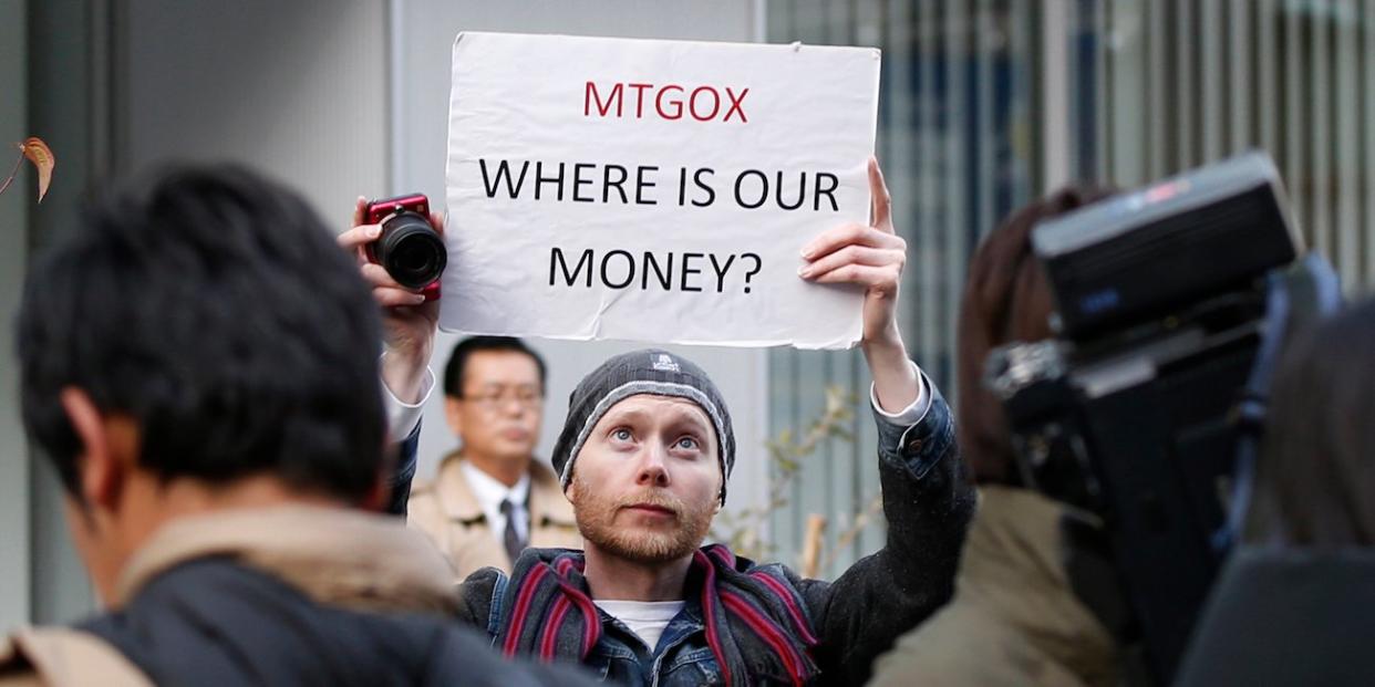 Kolin Burges, a self-styled cryptocurrency trader and former software engineer from London, holds up a placard to protest against Mt. Gox, in front of the building where the digital marketplace operator was formerly housed in Tokyo February 26, 2014. Japanese authorities are looking into the abrupt closure of Mt. Gox, the top government spokesman said on Wednesday in Tokyo's first official reaction to the turmoil at what was the world's biggest exchange for bitcoin virtual currency.