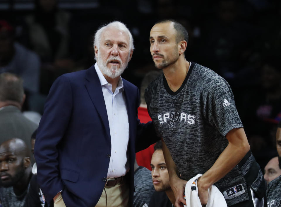 San Antonio Spurs head coach Gregg Popovich talks with San Antonio Spurs guard Manu Ginobili (20) against the Detroit Pistons in the first half of a preseason NBA basketball game in Auburn Hills, Mich., Monday, Oct. 10, 2016. (AP Photo/Paul Sancya)