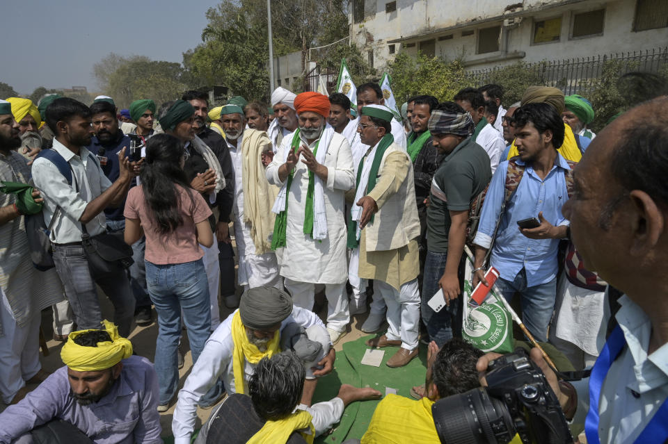 Farmer leader Rakesh Tikait, center wearing orange turban, joins Indian farmers who have been protesting to demand guaranteed crop prices gather at Ramlila ground in New Delhi, India, Thursday, March 14, 2024. (AP Photo)