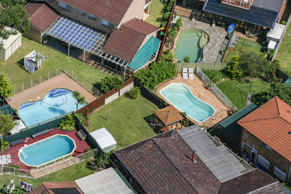 Aerial shot of the backyards of several houses.