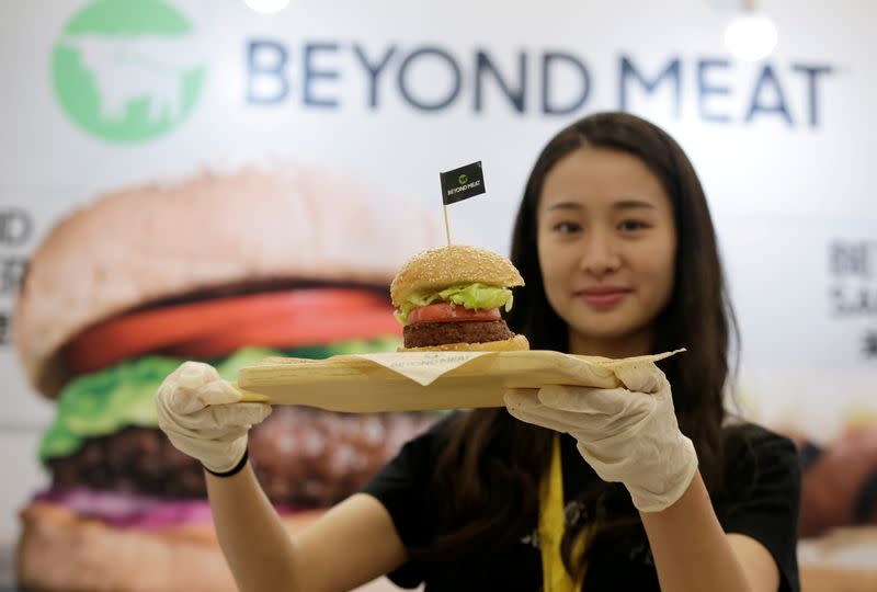 FILE PHOTO: Staff member displays a burger with a Beyond Meat plant-based patty at VeggieWorld fair in Beijing