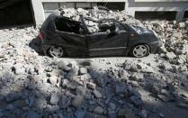 A destroyed car is seen following an earthquake in Amatrice, central Italy, August 24, 2016. REUTERS/Stefano Rellandini