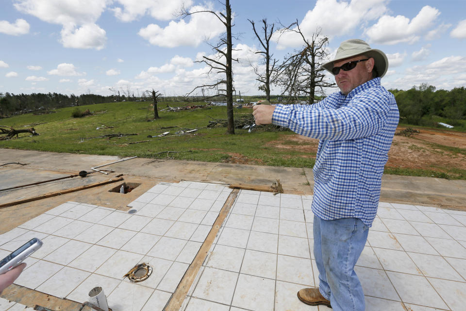 Terry Hartness, former owner of Hartness Farm, stands on the slab that was an office as he tells how the new owners held on to a full size refrigerator when a tornado hit the farm, a 12-chicken house operation that was leveled in Noxapater, Miss., Wednesday, April 30, 2014. The farm was sold on Friday and its new owners were at the farm when a tornado demolished the property and injured them. There were no chickens at the farm. (AP Photo/Rogelio V. Solis)