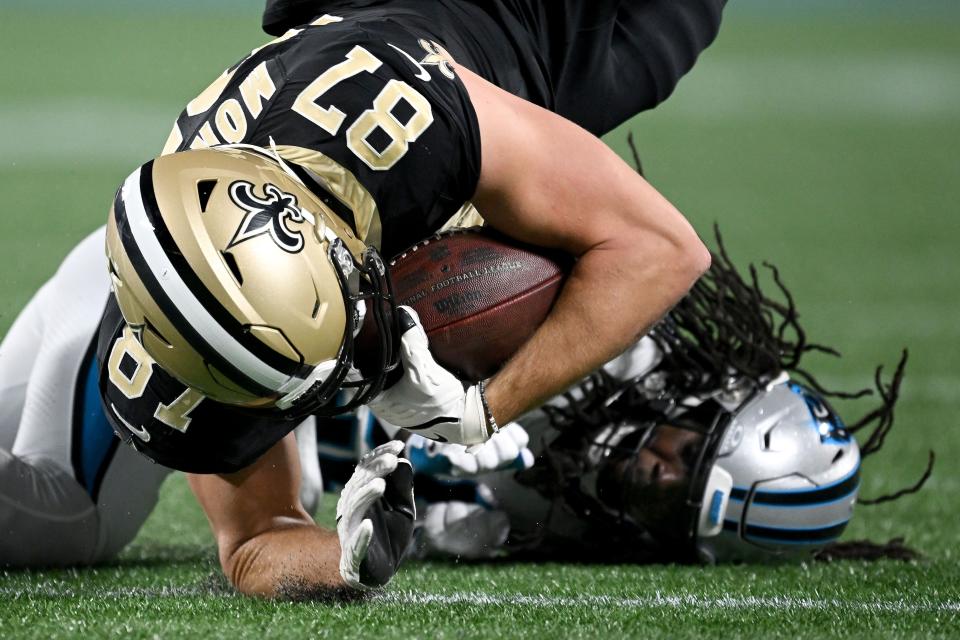 CHARLOTTE, NORTH CAROLINA - SEPTEMBER 18: Xavier Woods #25 of the Carolina Panthers tackles Foster Moreau #87 of the New Orleans Saints during the first quarter in the game at Bank of America Stadium on September 18, 2023 in Charlotte, North Carolina. (Photo by Grant Halverson/Getty Images)