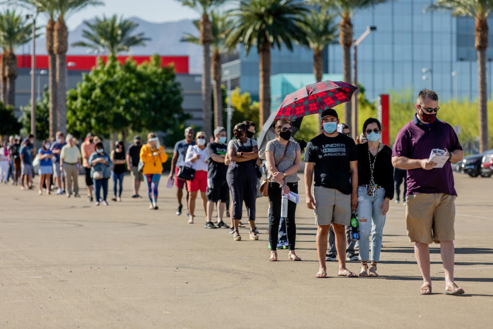 Voters wearing protective masks stand in line to cast ballots at an early voting polling location for the 2020 Presidential elections in Las Vegas, Nevada, U.S., on Saturday, Oct. 17, 2020.  / Credit: Roger Kisby/Bloomberg via Getty Images