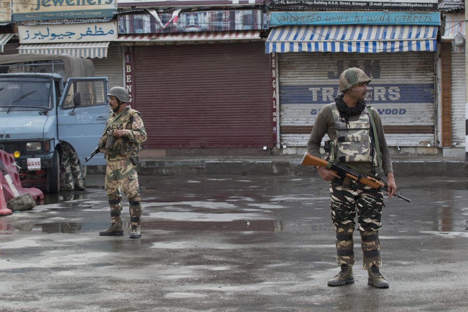 Indian Paramilitary soldiers stand guard on a deserted street during curfew in Srinagar, Indian controlled Kashmir, Thursday, Aug. 8, 2019. The lives of millions in India's only Muslim-majority region have been upended since the latest, and most serious, crackdown followed a decision by New Delhi to revoke the special status of Jammu and Kashmir and downgrade the Himalayan region from statehood to a territory. Kashmir is claimed in full by both India and Pakistan, and rebels have been fighting Indian rule in the portion it administers for decades. (AP Photo/Dar Yasin)