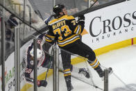 Columbus Blue Jackets left wing Eric Robinson (50) and Boston Bruins defenseman Charlie McAvoy (73) slam into the boards in the first period of an NHL hockey game, Thursday, March 30, 2023, in Boston. (AP Photo/Steven Senne)