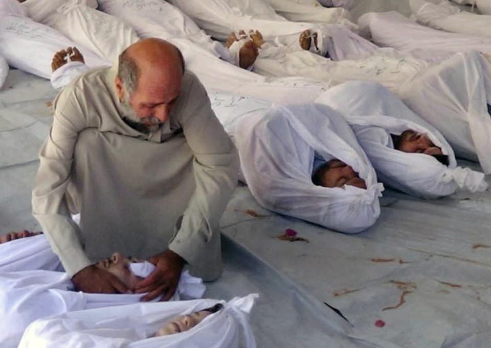 FILE - This Aug. 21, 2013, citizen journalism file image provided by the anti-government Media Office Of Douma City which has been authenticated based on its contents and other AP reporting, shows a Syrian man mourning over a dead body after an alleged poisonous gas attack fired by government forces, according to activists, in Douma town, Damascus, Syria. On Saturday, April 12, 2014 the Syrian government and rebel forces say poison gas has been used in a central village, injuring scores of people, while blaming each other for the attack. The main Western-backed opposition group, the Syrian National Coalition, says dozens of people were hurt in a poison gas attack Friday in the village of Kfar Zeita. State-run Syrian television on Saturday blamed members of the al-Qaida-linked Nusra Front for using chlorine gas at Kfar Zeita, killing two people and injuring more than 100. (AP Photo/Media Office Of Douma City, File)