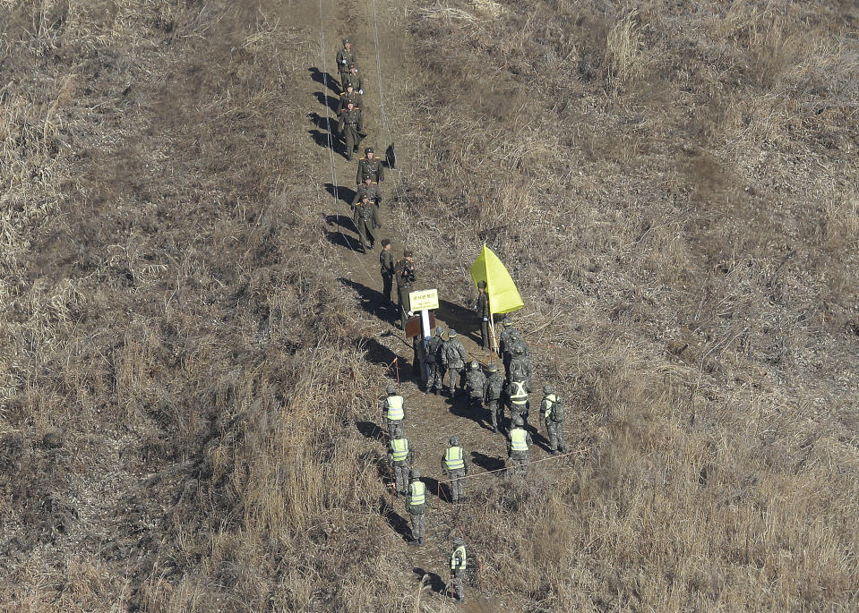 North Korean army soldiers, top, head to cross the Military Demarcation Line inside the Demilitarized Zone (DMZ) to inspect the dismantled South Korean guard post as South Korean army soldiers watch in the central section of the inter-Korean border in Cheorwon, Wednesday, Dec. 12, 2018. Dozens of South Korean soldiers visited former front-line North Korean guard posts on Wednesday to verify their recent removal as part of warming diplomacy by the rival Koreas while U.S.-North Korea nuclear disarmament efforts remain stalled. (AP Photo/Ahn Young-joon, Pool)