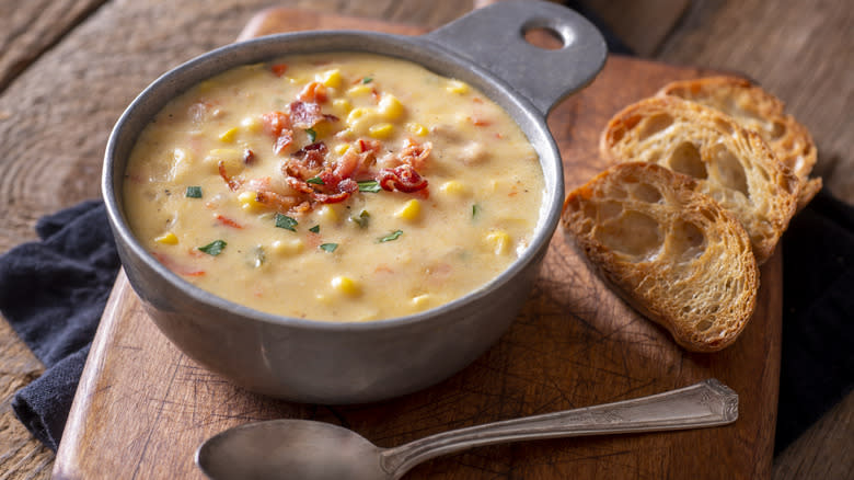 A bowl of homemade corn chowder with bread