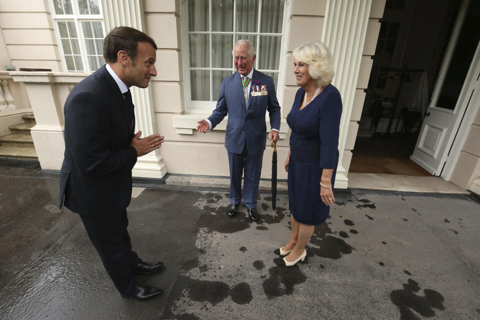 ARCHIVO – El príncipe Carlos de Gran Bretaña y Camila, la duquesa de Cornualles reciben al presidente francés Emmanuel Macron en Clarence House en Londres, el 18 de junio de 2020. Los disturbios en Francia le han restado lustre al primer viaje al extranjero del rey Carlos III como monarca, con trabajadores en huelga que se niegan a desdoblar alfombras rojas en medio de protestas por la reforma a las pensiones y críticos que piden que se cancele la visita por completo. (Jonathan Brady/Pool via AP, archivo)