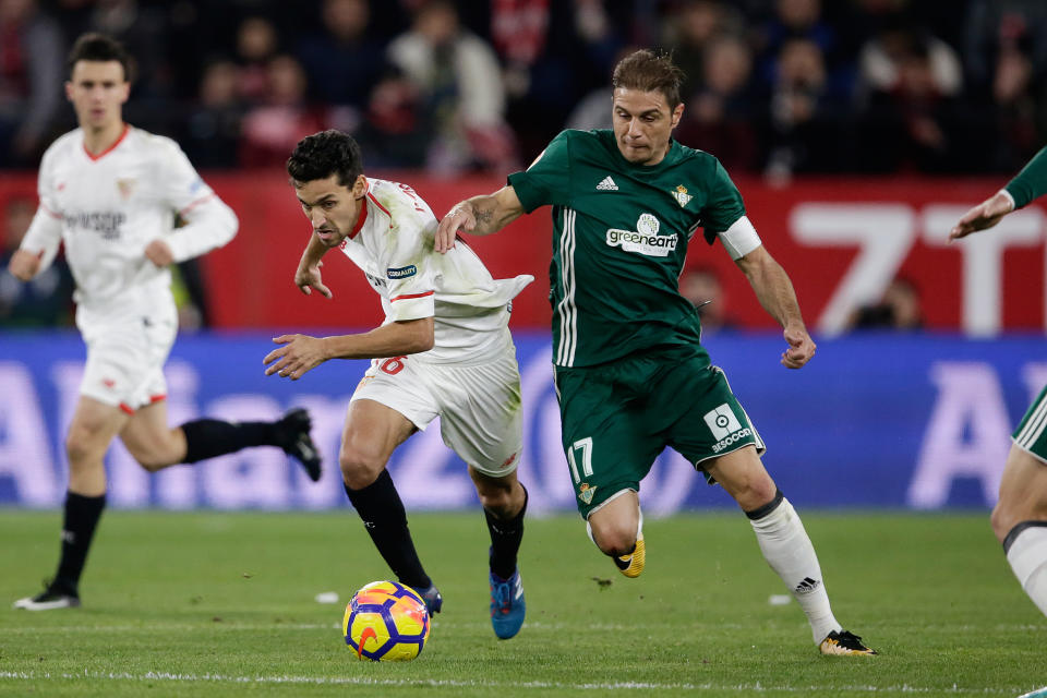 Jesús Navas y Joaquín luchando por un balón durante un partido.