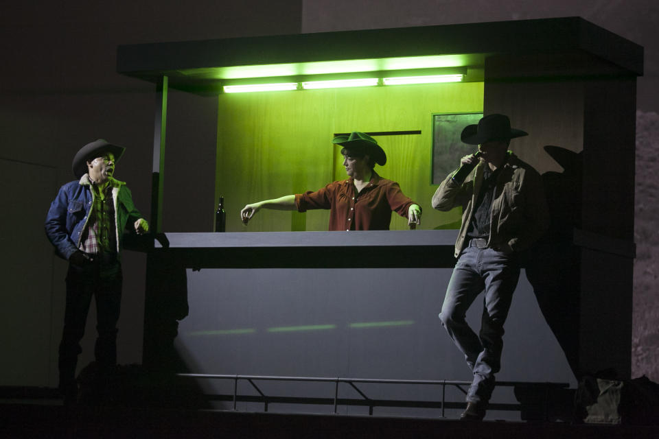 In this photo taken on Friday, Jan. 24, 2014, American tenor Tom Randle (Jack Twist), left , Welsh contralto Hillary Summers (Bartender), center, and Canadian bass-baritone Daniel Okulitch (Ennis del Mar), right , perform during the press rehearsal of the production "Brokeback Mountain" at the Teatro Real, in Madrid, Spain. It was a short story, then a Hollywood movie. Now the tragic tale of cowboys in love is being reinvented again: Brokeback Mountain _ the opera. Ahead of its world premiere in Madrid, author Annie Proulx told The Associated Press that the form of opera presented an opportunity to explore the complexities of the tale in a way neither her own short story nor the movie by director Ang Lee were able to do. (AP Photo/Gabriel Pecot)