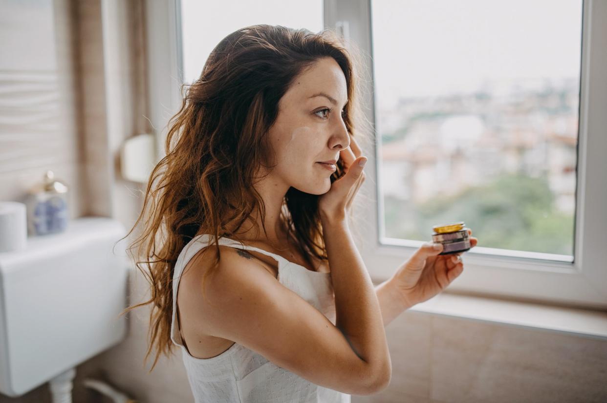 Woman applying lotion or moisturizer