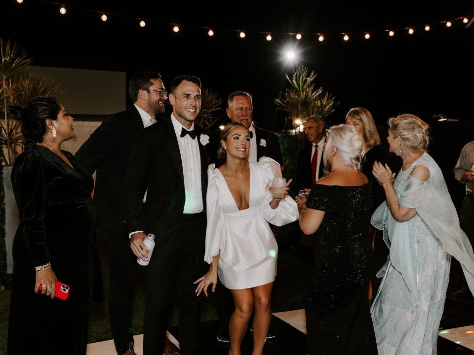 A bride and groom dance on a black checkerboard dance floor.