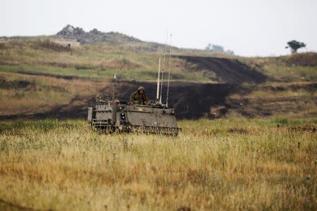 An Israeli soldier sits on an APC as it drives near the Israeli side of the border with Syria in the Israeli-occupied Golan Heights, Israel May 9, 2018. REUTERS/Amir Cohen