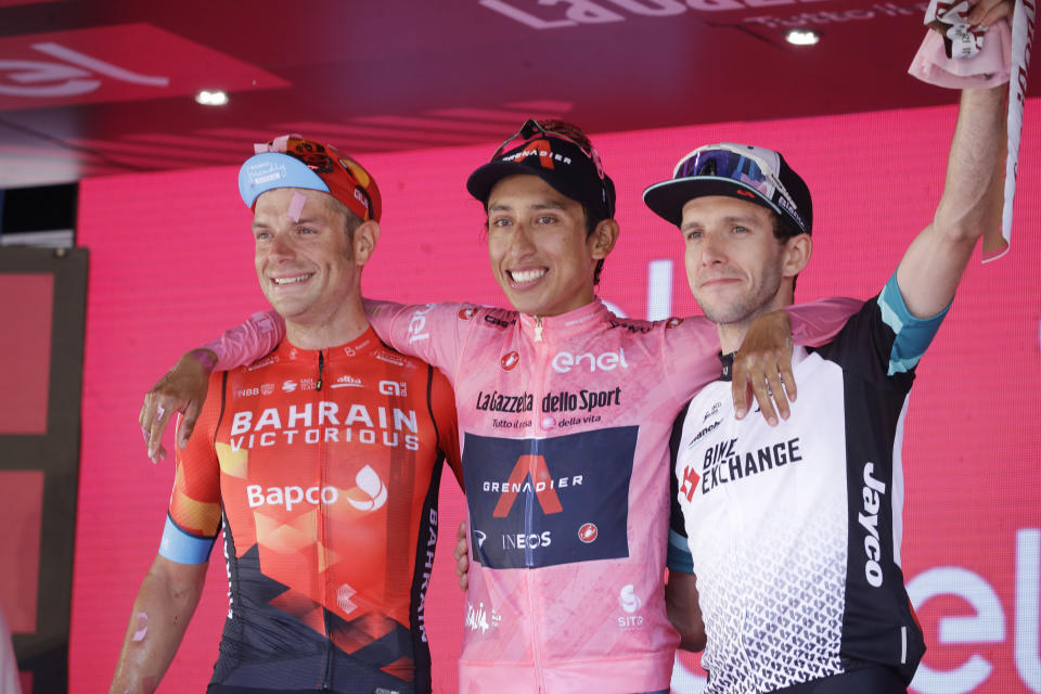 Colombia's Egan Bernal is flanked by runner-up Italy's Damiano Caruso, and Third placed Britain's Simon Yates, right, as he celebrates on podium after completing the final stage to win the Giro d'Italia cycling race, in Milan, Italy, Sunday, May 30, 2021. (AP Photo/Luca Bruno)