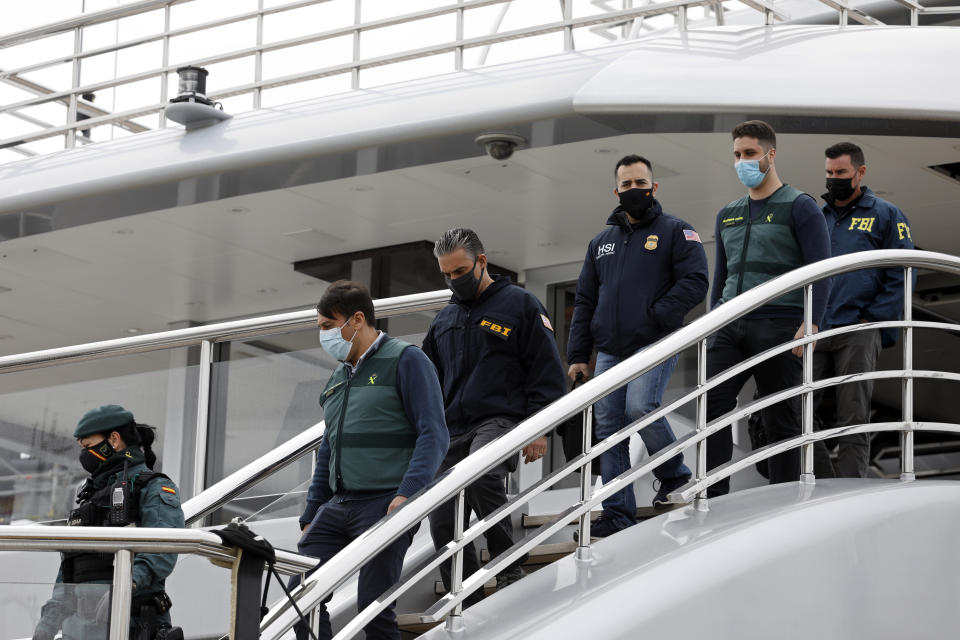 FILE - Civil Guards accompany U.S. FBI agents and a U.S.Homeland Security agent from the yacht called Tango in Palma de Mallorca, Spain, April 4, 2022. Two businessmen have been charged with trying to conceal a sanctioned Russian oligarch's ownership of the luxury yacht seized in Spain last year by the U.S. government, the Justice Department said Friday, Jan. 20, 2023. (AP Photo/Francisco Ubilla, File)