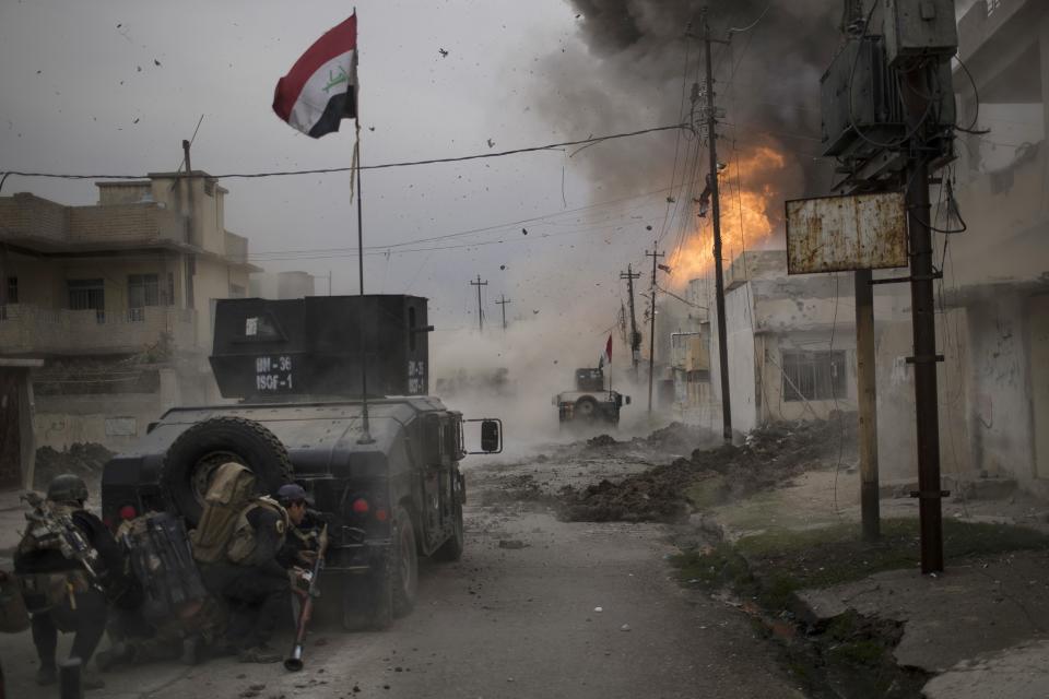 FILE - A car bomb explodes next to Iraqi special forces armored vehicles as they advance toward Islamic State held territory in Mosul, Iraq, Nov. 16, 2016. (AP Photo/Felipe Dana, File)