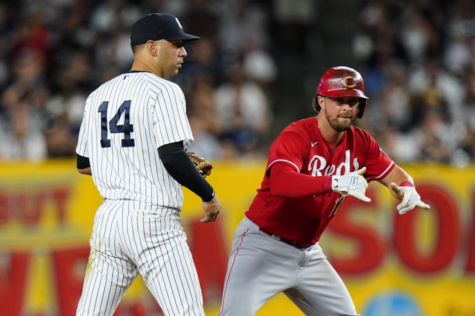 New York Yankees' Marwin Gonzalez, left, watches as Cincinnati Reds' Kyle Farmer gestures to teammates after hitting a two-run double during the eighth inning of a baseball game Thursday, July 14, 2022, in New York. (AP Photo/Frank Franklin II)