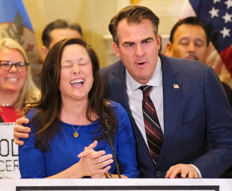Gov. Kevin Stitt leans in Tuesday to say something as House Minority Leader Cyndi Munson prepares for her remarks at the signing ceremony for the grocery tax cut bill.