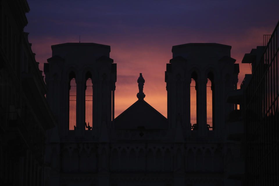 The sun sets behind the Notre Dame church in Nice, southern France, after a knife attack took place on Thursday, Oct. 29, 2020. An attacker armed with a knife killed at least three people at a church in the Mediterranean city of Nice, prompting the prime minister to announce that France was raising its security alert status to the highest level. (AP Photo/Daniel Cole)