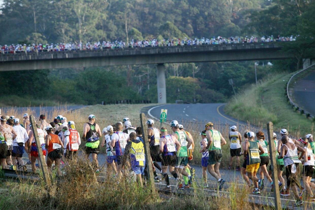 Runners are seen on a road and an overpass.