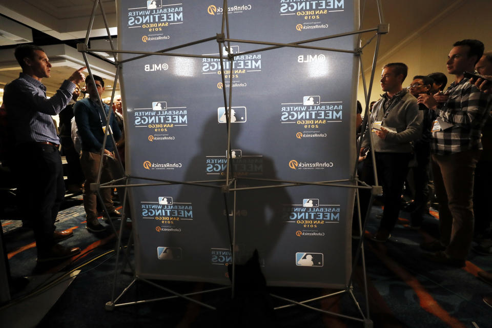 San Francisco Giants manager Gabe Kapler, center, casts a shadow as he speaks with reporters during the Major League Baseball winter meetings, Tuesday, Dec. 10, 2019, in San Diego. (AP Photo/Gregory Bull)